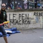 Un hombre pasa junto a un pintada en Saint Denis donde se lee "Ni Le Pen ni Macron"