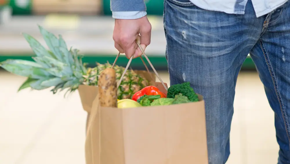 Bolsa de papel cargada de fruta y verdura en un supermercado.