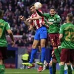 Sergio Escudero y Savic saltan a por un balón en el Atlético - Granada