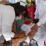 Un niña es vacunada contra el coronavirus por personal médico hoy, en el Paso Canoas, frontera entre Panamá y Costa Rica. Panamá y Costa Rica relanzaron este viernes la Semana de la Vacunación de las Américas, tras dos años de suspensión por la pandemia y en medio de un descenso en el continente de la cobertura de inmunización, con un evento en la frontera común en la que fueron vacunados niños de los dos países. EFE/ Marcelino Rosario