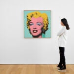 Una mujer observa la obra "Shot Sage Blue Marilyn", un llamativo retrato ejecutado por el artista estadounidense Andy Warhol en 1964 que hoy se pone a la venta