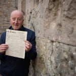 Nick Lloyd, ante los impactos de metralla de San Felipe Neri con un ejemplar del «New York Times» del día siguiente al bombardeo