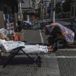 Un repartidor de comida a domicilio descansa en plena calle en Shanghai