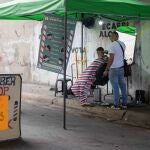 Un barbero atiende a un cliente en una barbería callejera, el 12 de mayo de 2022, en Caracas (Venezuela)