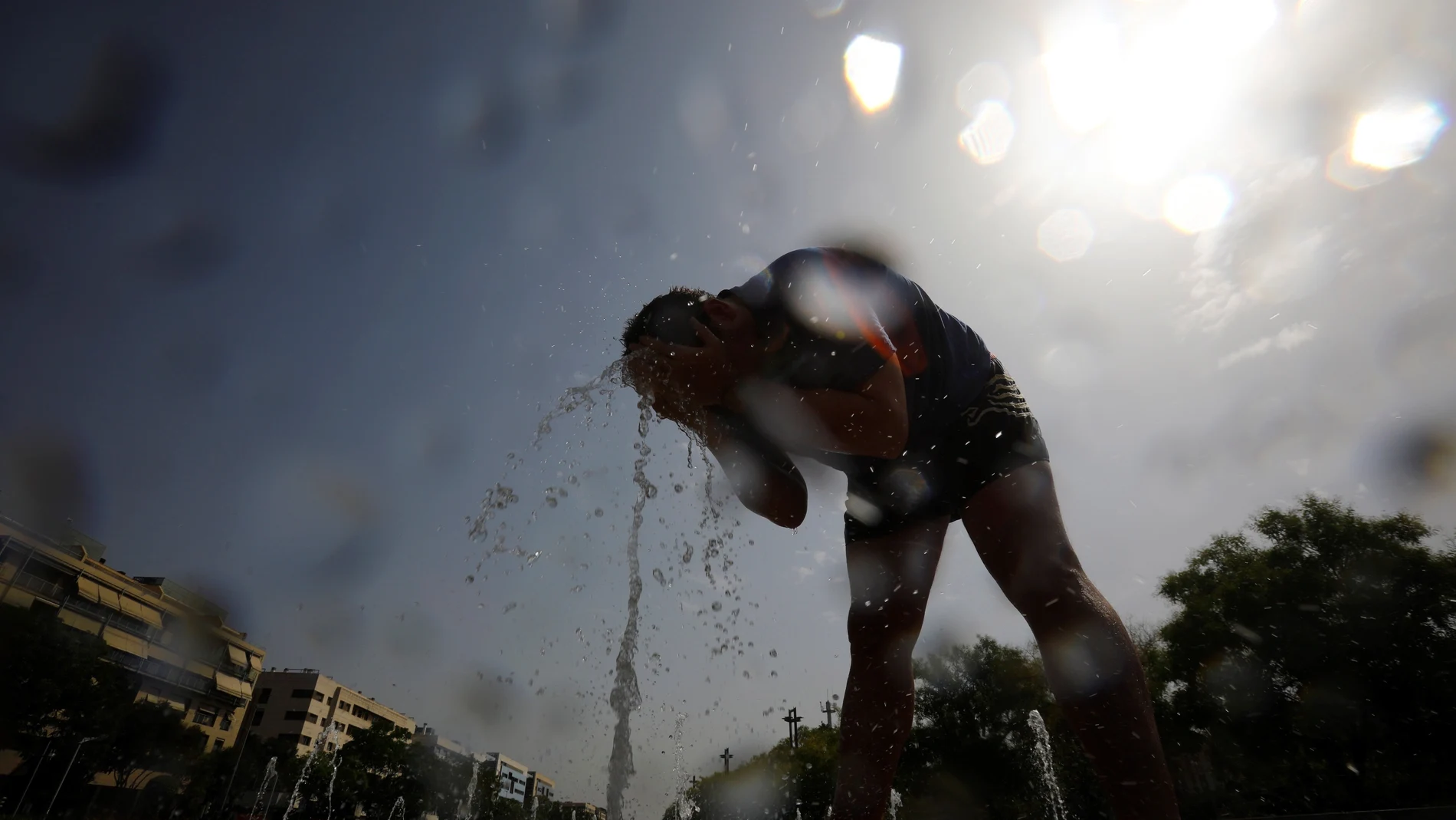 Un hombre se moja con agua de una fuente en Córdoba