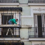 Un trabajador repara el balcón de una vivienda en Madrid