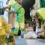 Trabajadores municipales recogiendo bolsas de recogida selectiva.