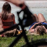 Dos mujeres toman el sol en el jardín del rio Turia de Valencia.