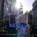 Una manifestante sostiene un cartel pidiendo la dimisión de Boris Johnson a la puerta de Downing Street