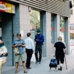 Varias personas pasan por delante de una oficina del Servicio Público de Empleo Estatal