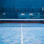 Paddle tennis court, net, racket, balls.