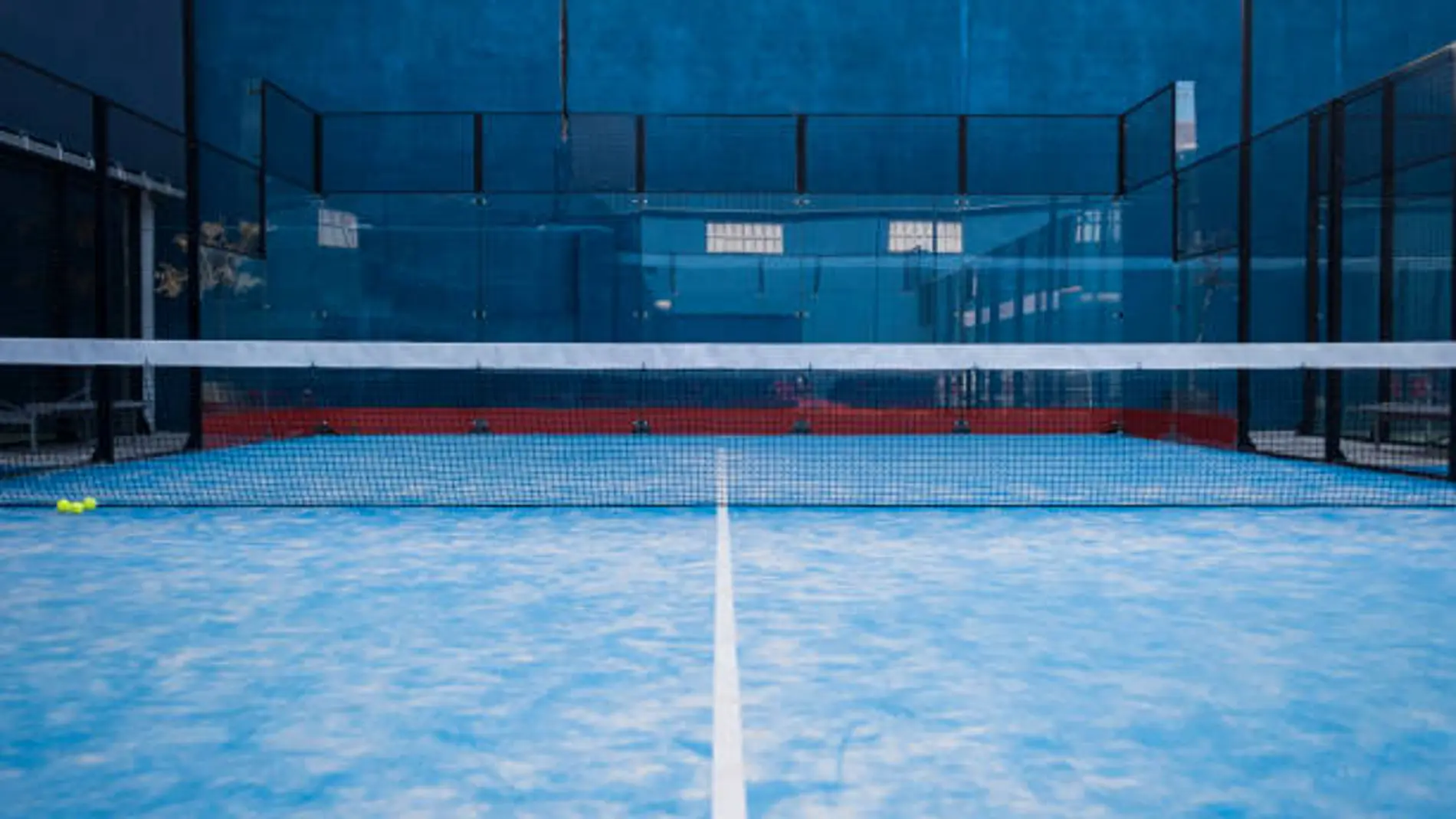 Paddle tennis court, net, racket, balls.