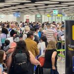 Cientos de pasajeros hacen cola hoy en un control de pasaportes del aeropuerto de Madrid-Barajas