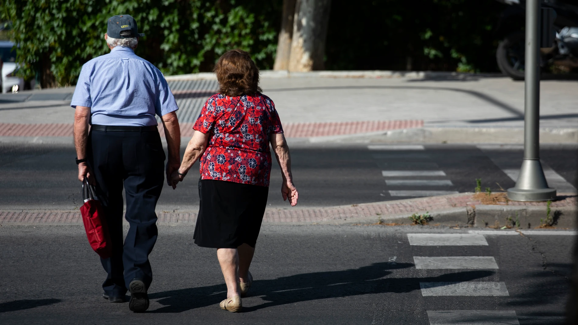Imagen de una pareja de personas mayores paseando por Madrid
