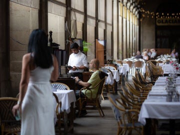 Un camarero atiende a una mesa en la plaza Real de Barcelona