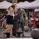 Personas se refrescan en una fuente en plena ola de calor