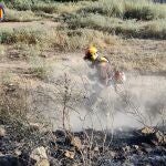 Un agente de la brigada forestal actuando sobre el terreno incendiado en Riba-roja
