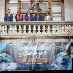 Miembros de la Associació de Juristes Valencians en el balcón del Ayuntamiento de Valencia junto a una pancarta reivindicativa