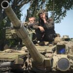 Soldados ucranianos hacen la señal de la victoria sobre un tanque en la región de Donetsk