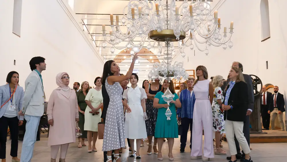 La Reina Letizia con los acompañantes de los mandatarios que asisten a la cumbre de la OTAN en su visita a la Fábrica de Vidrio en la Granja de San Idelfonso, Segovia
