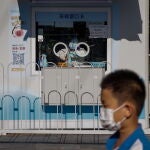 Un trabajador sanitario descansa en su puesto "movil" de cribado PCR, en Beijin (China)
