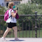 Una señora, que porta mascarilla, cruza el puente de Isabel II, a 7 de julio de 2022 en Sevilla