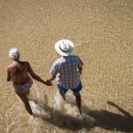 Una pareja pasea por la orilla de la playa