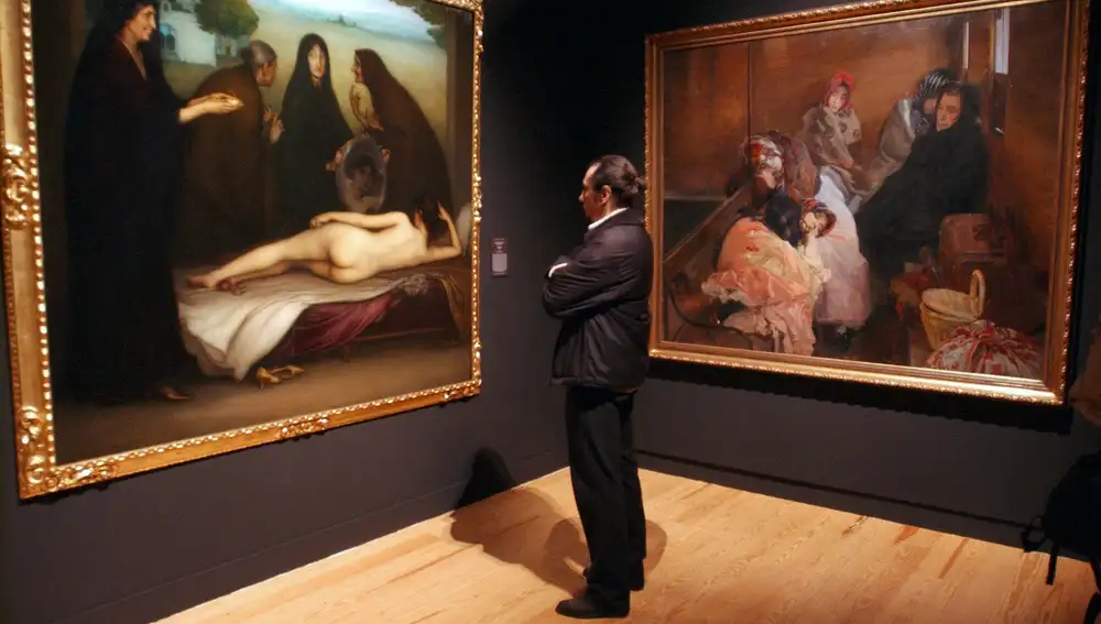 Un visitante observa "El pecado" de Julio Romero de Torres (i), a su derecha, "Trata de Blancas" de Joaquín Sorolla, en la exposición inaugurada "Tres mitos españoles. La Celestina, Don Quijote y Don Juan".
