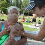 Una madre aplica crema solar a su bebé en una piscina de Palencia