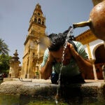 Un turista se refresca en una de las fuentes del patio de los naranjos de la Mezquita-Catedral de Córdoba
