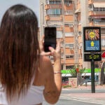 Una mujer fotografía un termómetro que marca 50 grados 
