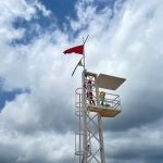 Un socorrista iza la bandera roja
