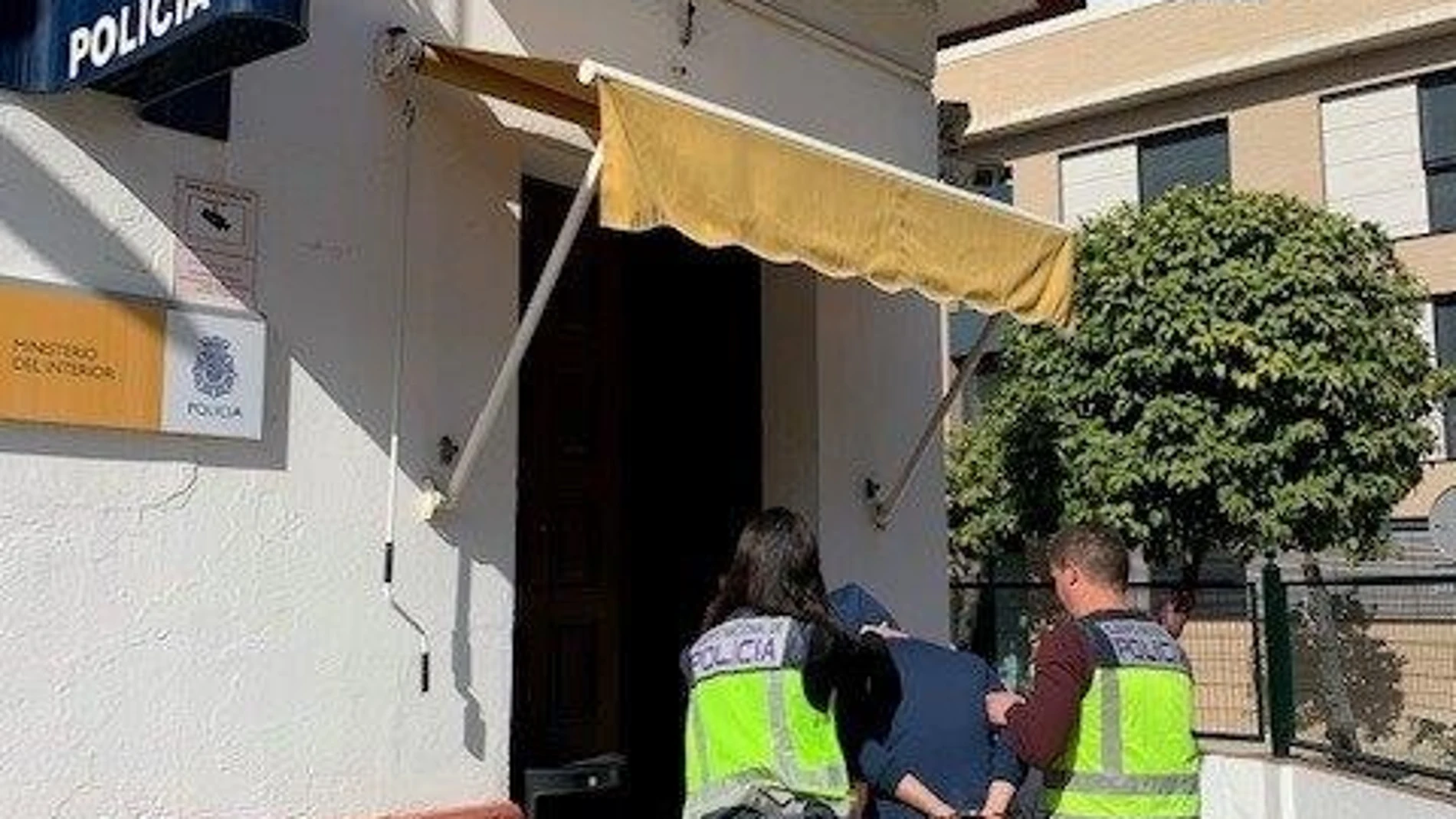 Dos agentes conducen a un detenido al interior de la Comisaría de Policía de Nervión