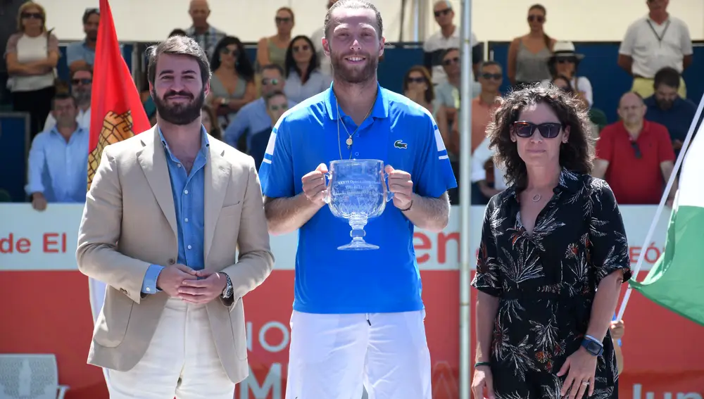 El tenista francés Hugo Grenier (c) posa con el vicepresidente de la Junta de Castilla y León, Juan García-Gallardo (i), y de la directora del Open Castilla y León, la extenista Virgiia Ruano (d) tras proclamarse campeón de la competición este domingo en el municipio segoviano Villa de El Espinar