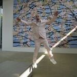 El artista Damien Hirst salta delante de una de sus pinturas