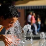 Una mujer se refresca en la fuente de la plaza de las Tendillas de Córdoba