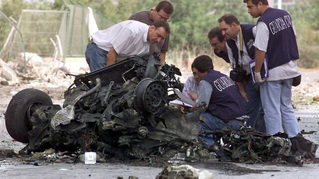 Guardias civiles examinan los restos del coche bomba utilizado por ETA en el atentado de Santa Pola en 2002