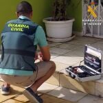Un agente de Guardia Civil recoge vestigios del apuñalamiento de un hombre a las puertas de un club cannábico de Almería. GUARDIA CIVIL