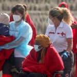 -FOTODELDÍA- ARRECIFE (LANZAROTE), 13/08/2022.- Una miembro de la Cruz Roja envuelve a un menor en una manta tras la llegada de una embarcación neumática con 51 inmigrantes a bordo, cuatro de ellos menores, al muelle de La Cebolla, Arrecife (Lanzarote), después de ser rescatada por Salvamento Marítimo cuando navegaba a unas 36 millas de Arrecife este sábado. EFE/Adriel Perdomo