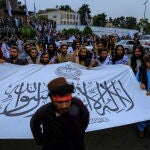 Talibanes exhiben su bandera frente a la Embajada de EE UU en Kabul en el primer aniversario de su toma del poder