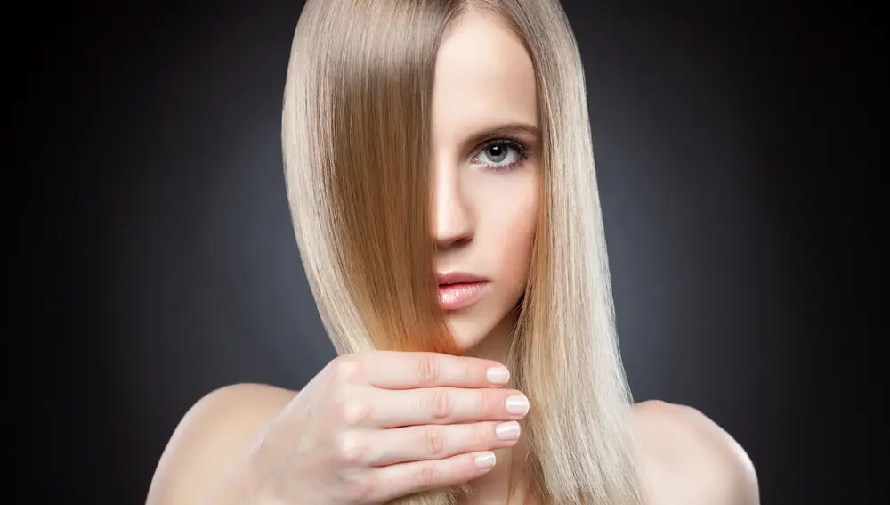 Perfil de una chica joven con el pelo recto rubio largo. Belleza