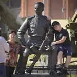 La gente posa para una foto en una escultura de Mikhail Kalashnikov, creador del rifle de asalto Kalashnikov en el museo de Artillería en San Petersburgo, Rusia