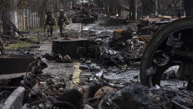 Soldados caminan entre tanques rusos destruidos en Bucha, en las afueras de Kiev, Ucrania, el 3 de abril de 2022.