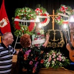 Los cuidadores que se ocuparon de él en sus últimos días depositan un ramo de flores sobre el féretro de Manolo Sanlúcar. Al lado, su guitarra