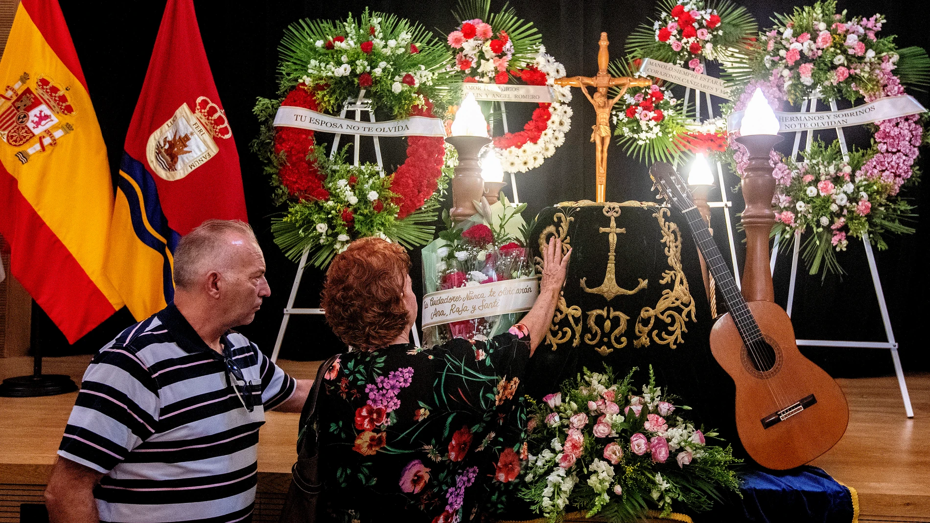 Los cuidadores que se ocuparon de él en sus últimos días depositan un ramo de flores sobre el féretro de Manolo Sanlúcar. Al lado, su guitarra
