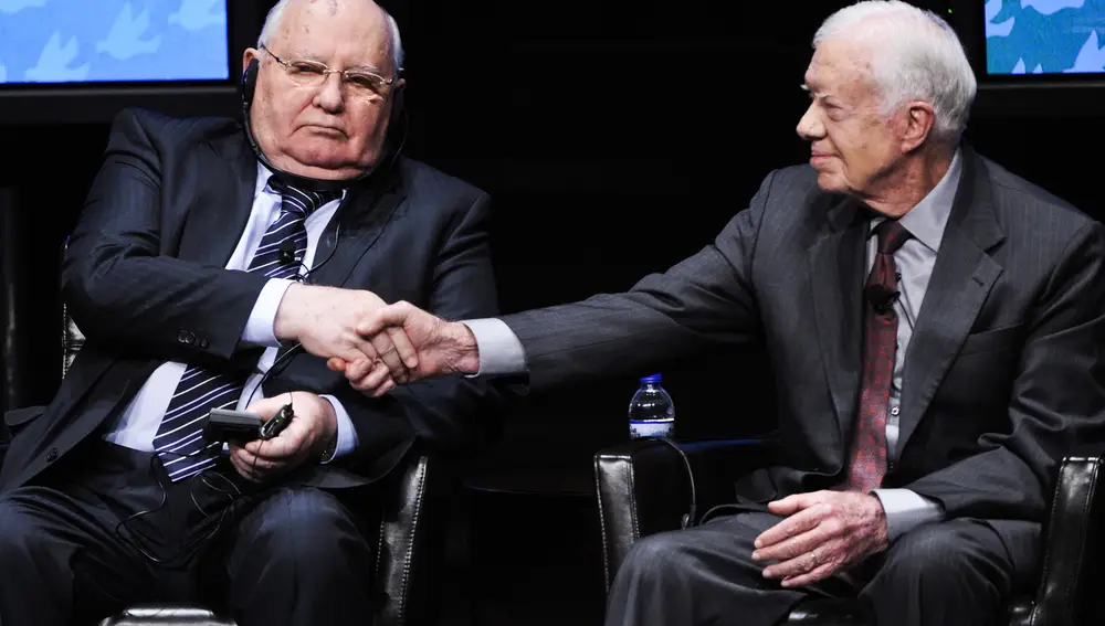 El ex presidente estadounidense Jimmy Carter (d) estrecha la mano del ex presidente soviético Mijaíl Gorbachov (i), al comienzo de una mesa redonda en la 12ª Cumbre Mundial de Premios Nobel de la Paz en la Universidad de Illinois en Chicago, Illinois, Estados Unidos, el 23 de abril de 2012