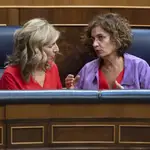 La vicepresidenta segunda del Gobierno, Yolanda Díaz (i), conversa con la ministra de Hacienda, María Jesús Montero, durante una sesión extraordinario en el Congreso