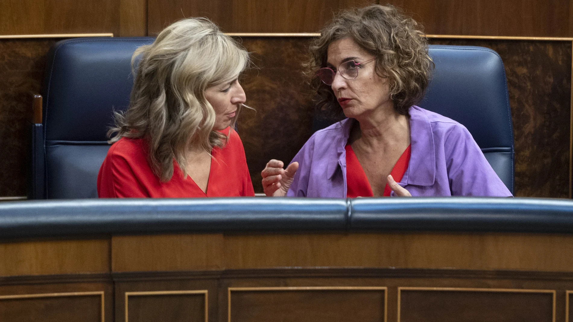 La vicepresidenta segunda del Gobierno, Yolanda Díaz (i), conversa con la ministra de Hacienda, María Jesús Montero, durante una sesión extraordinario en el Congreso