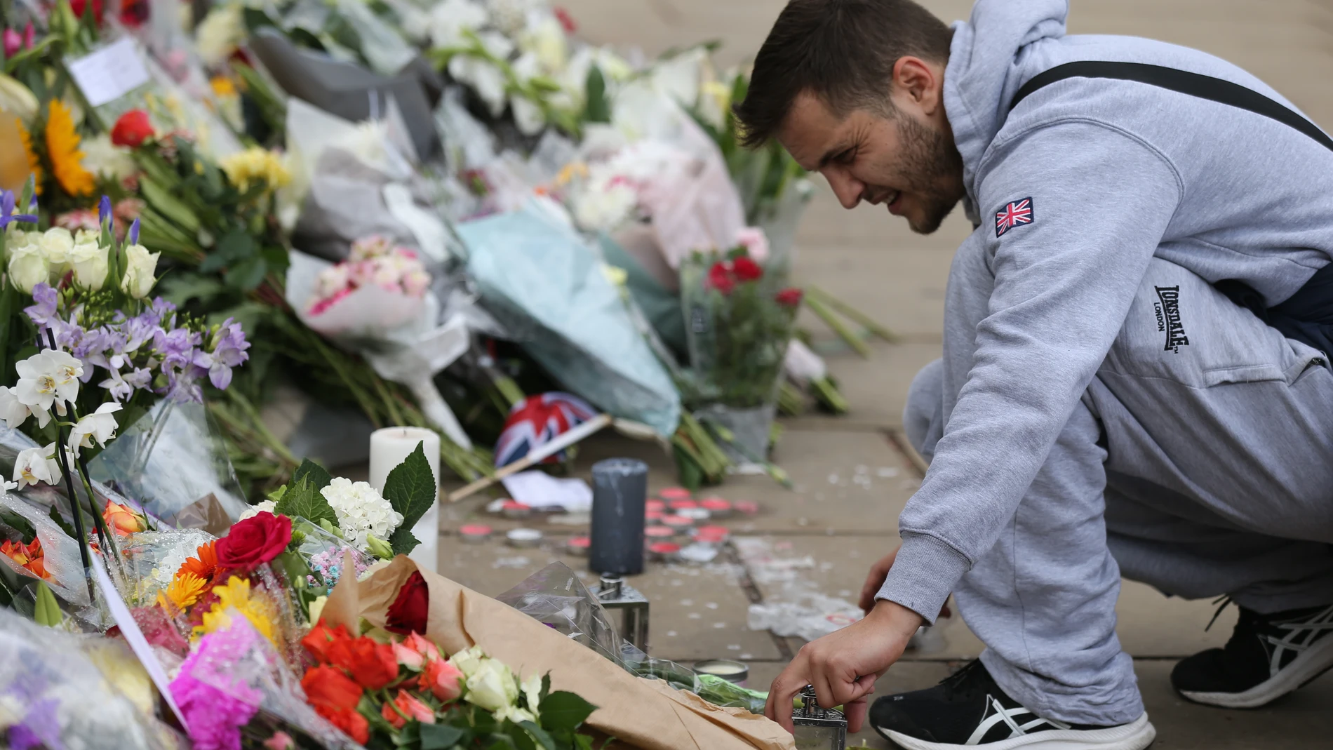 Un hombre coloca flores en recuerdo a la reina Isabel II, en el Buckingham Palace, a 9 de septiembre de 2022, en Londres (Reino Unido).