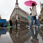 Una mujer cruza la madrileña calle Alcalá el pasado jueves